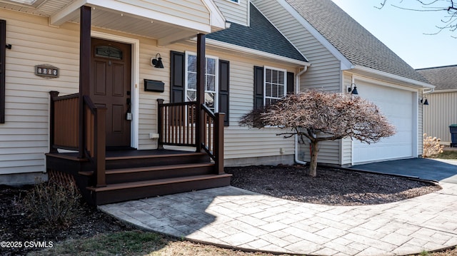 doorway to property featuring roof with shingles and an attached garage