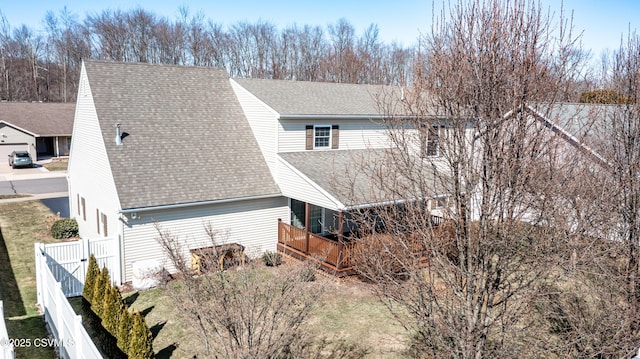 view of side of property featuring a gate, a shingled roof, and fence