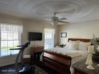 bedroom featuring multiple windows, a ceiling fan, and baseboards