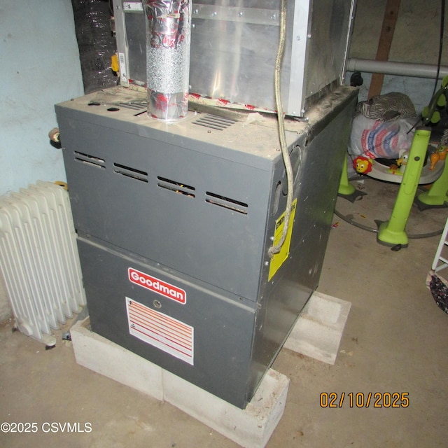 utility room with heating unit and radiator