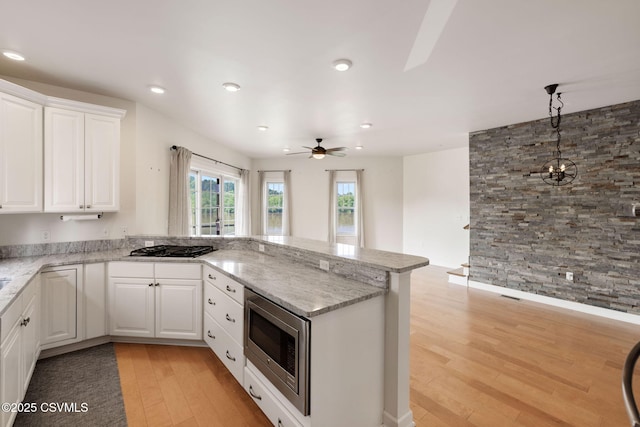 118 Jacobs Landing Way, Danville, PA 17821 - kitchen featuring stainless steel microwave, light wood-style flooring, a peninsula, light stone counters, and recessed lighting
