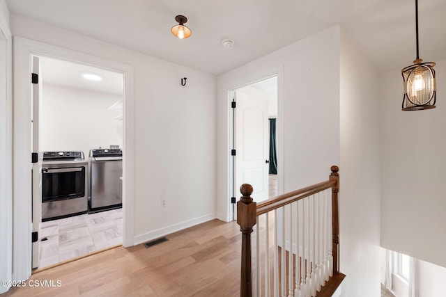 118 Jacobs Landing Way, Danville, PA 17821 - corridor featuring washing machine and clothes dryer, an upstairs landing, and light wood-style floors