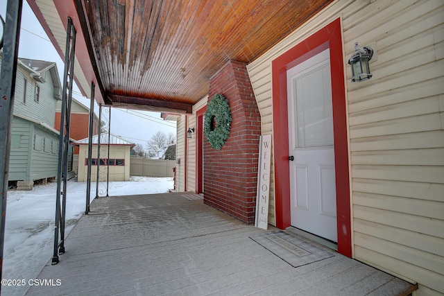 snow covered patio featuring covered porch