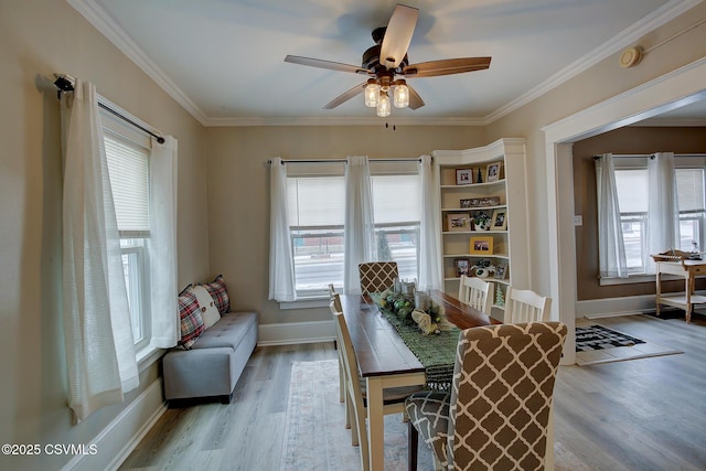 dining space featuring ornamental molding, light wood finished floors, a ceiling fan, and baseboards