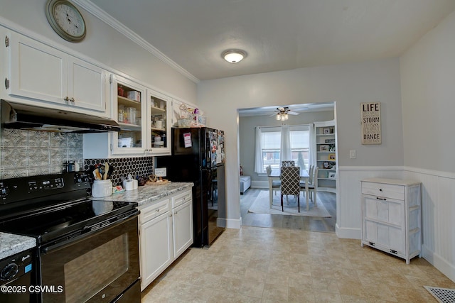 kitchen featuring black appliances, under cabinet range hood, glass insert cabinets, and white cabinets