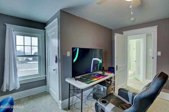 office area featuring light carpet, ceiling fan, and baseboards