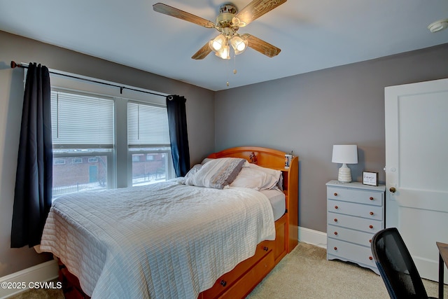 bedroom with a ceiling fan, light carpet, and baseboards