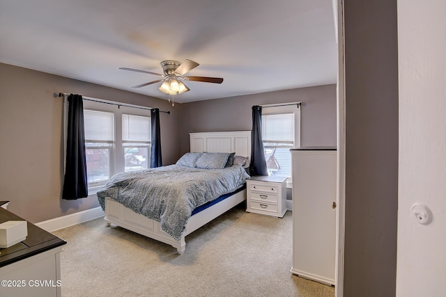 bedroom featuring light carpet, ceiling fan, and baseboards