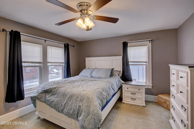 bedroom featuring ceiling fan, baseboards, and light colored carpet