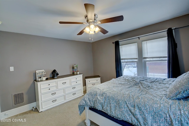 bedroom with baseboards, visible vents, a ceiling fan, and light colored carpet