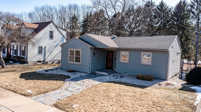 ranch-style house with a front lawn and roof with shingles