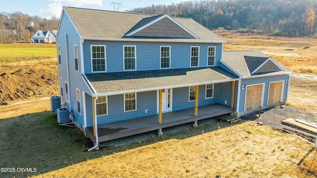 view of front of home with a shingled roof, covered porch, and central AC unit