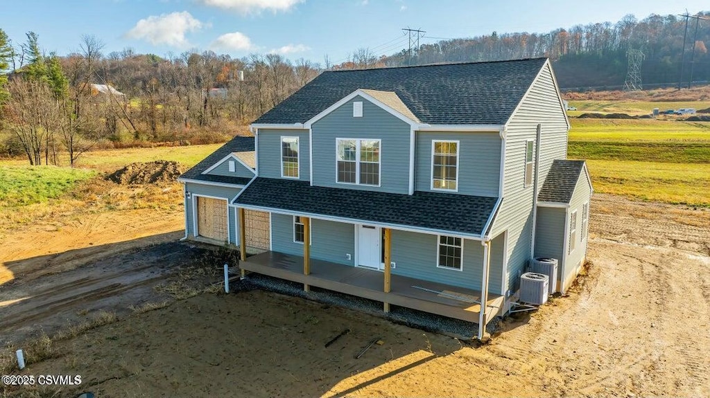 view of front of home with roof with shingles, a porch, and central AC unit