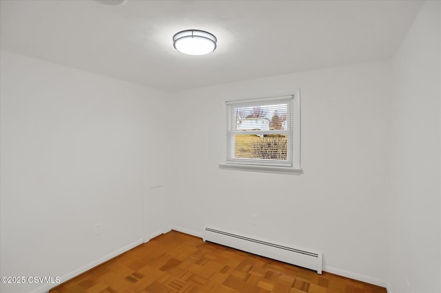 empty room featuring baseboards and a baseboard heating unit