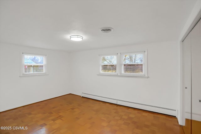 spare room with a baseboard heating unit and visible vents