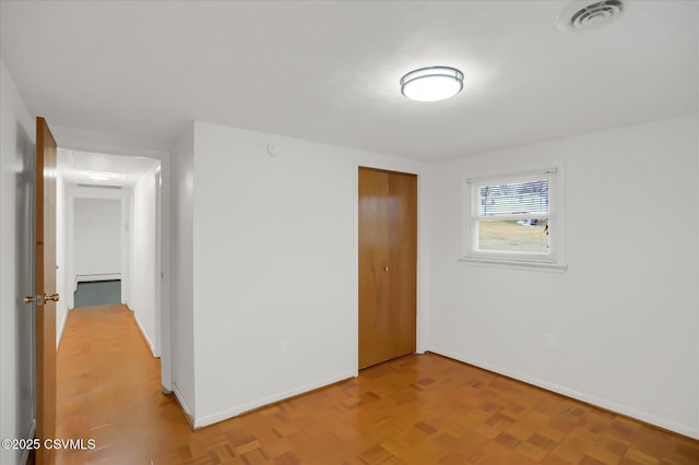 unfurnished room featuring baseboards and visible vents