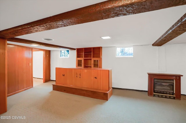 below grade area with visible vents, a fireplace, and carpet flooring