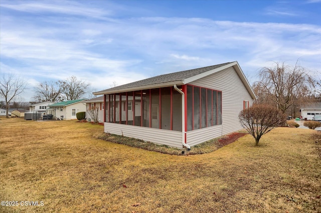 view of home's exterior featuring a lawn and a sunroom