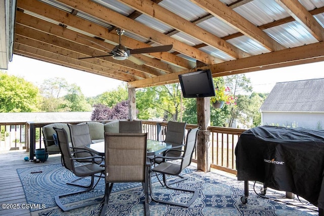 deck featuring outdoor dining area, area for grilling, and a ceiling fan