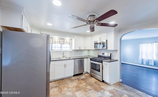 kitchen with white cabinetry, appliances with stainless steel finishes, backsplash, and a sink