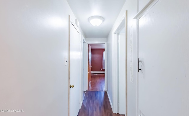 corridor featuring dark wood-style flooring, baseboard heating, and baseboards