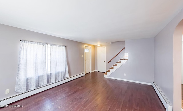 interior space with a baseboard heating unit, arched walkways, stairway, and wood finished floors