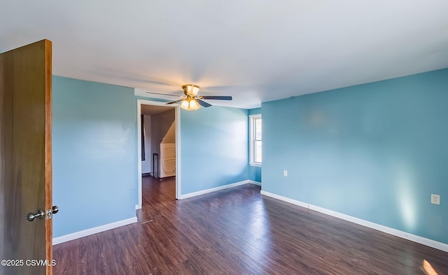 spare room featuring ceiling fan, dark wood-style flooring, and baseboards