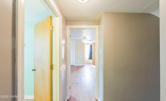 corridor with wood finished floors and baseboards