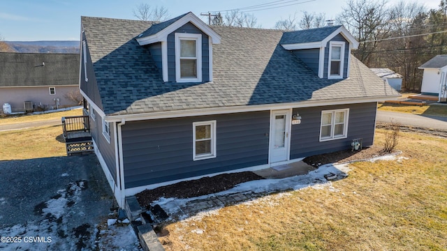 view of front of home with a front yard and roof with shingles