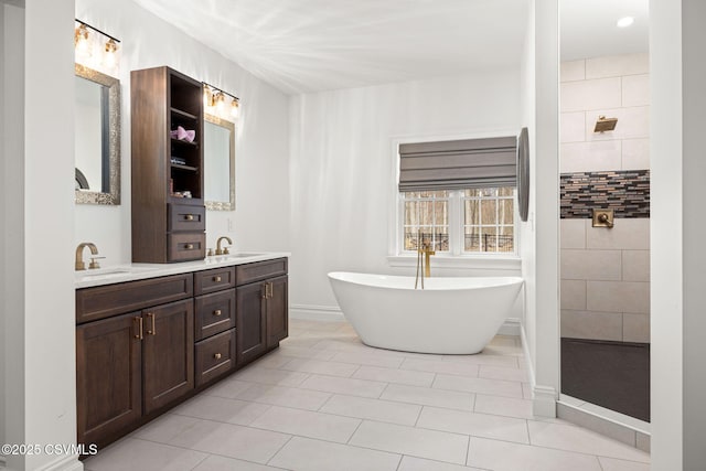 bathroom featuring tile patterned flooring, vanity, and a washtub