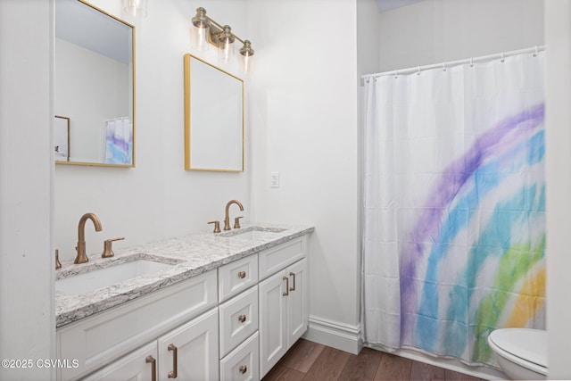 bathroom with wood-type flooring, toilet, curtained shower, and vanity