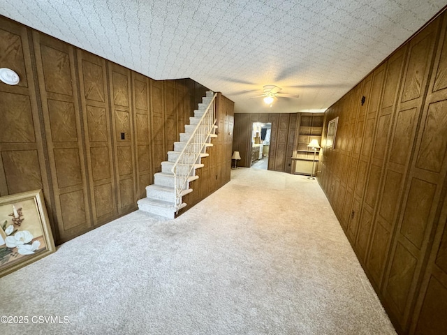 interior space with ceiling fan and wood walls