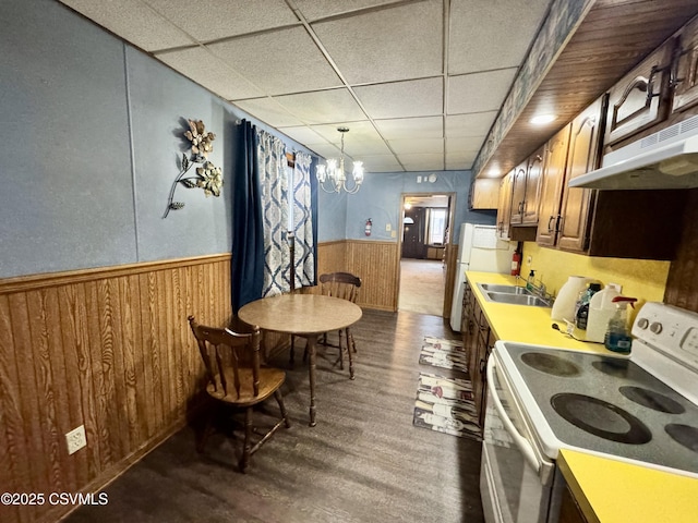 kitchen with dark wood-type flooring, a paneled ceiling, decorative light fixtures, a chandelier, and electric stove