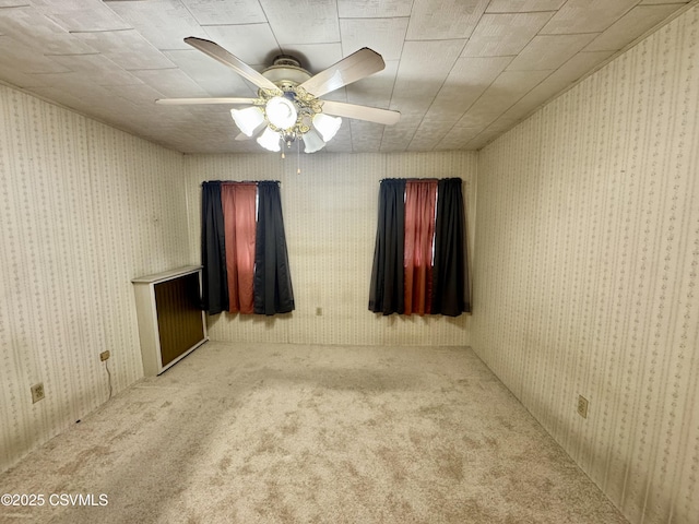 carpeted spare room featuring ceiling fan