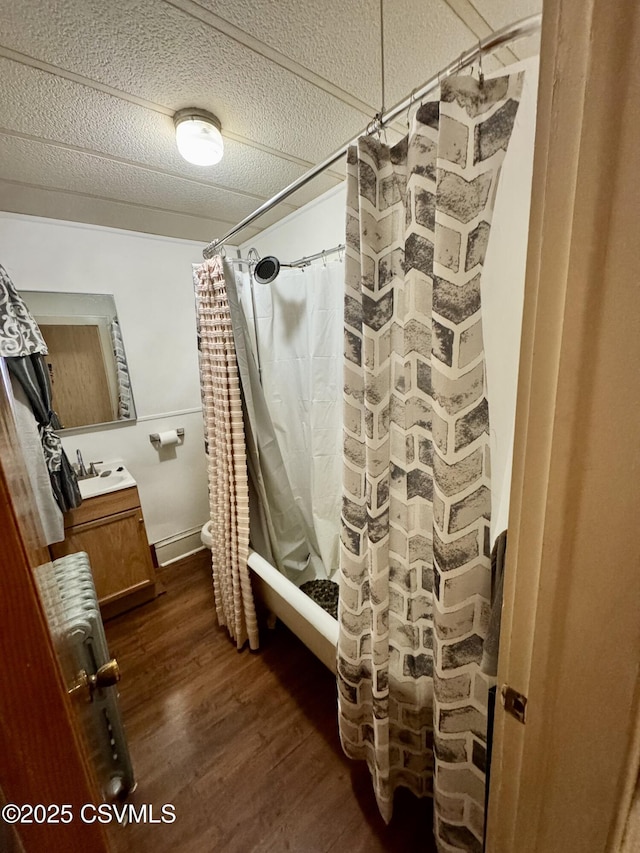 bathroom featuring vanity, shower / tub combo, wood-type flooring, and a textured ceiling