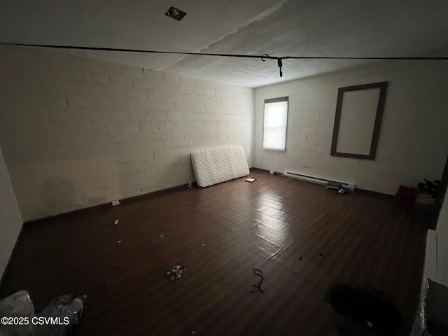 empty room featuring dark wood-style flooring and concrete block wall