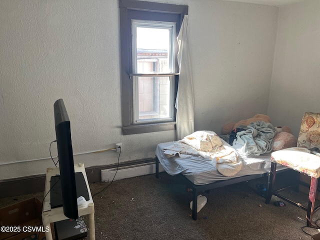 bedroom featuring a textured wall, dark carpet, and baseboard heating