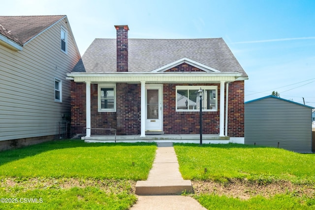 1041 Pine St, Kulpmont, PA 17834 - bungalow-style home featuring brick siding, covered porch, roof with shingles, a front lawn, and a chimney