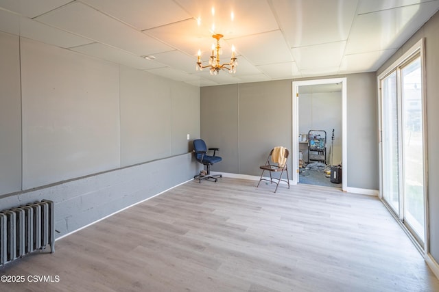 1041 Pine St, Kulpmont, PA 17834 - spare room with radiator heating unit, healthy amount of natural light, a chandelier, and wood finished floors