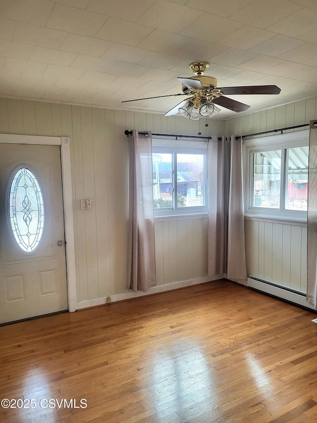 entryway with light wood-type flooring, plenty of natural light, and a baseboard heating unit