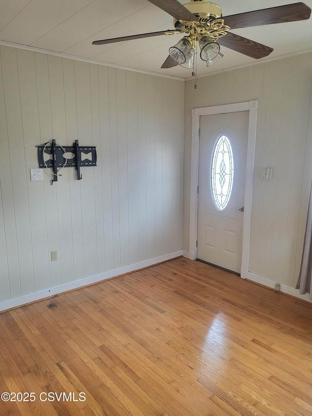 foyer featuring crown molding, light wood-style flooring, and baseboards