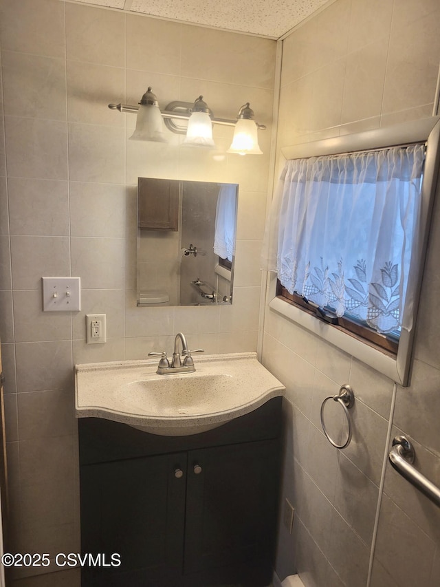 bathroom with tasteful backsplash, vanity, and tile walls