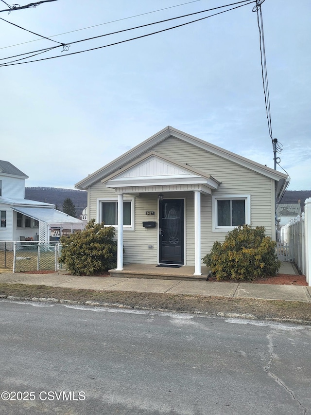 bungalow featuring fence