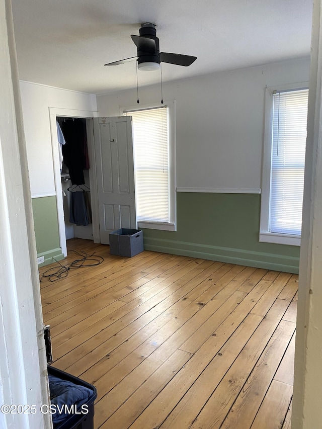 empty room with a ceiling fan, baseboards, and hardwood / wood-style floors