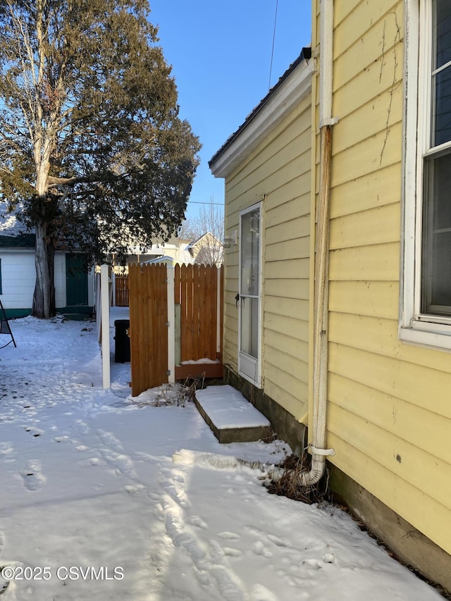 view of snowy exterior with fence