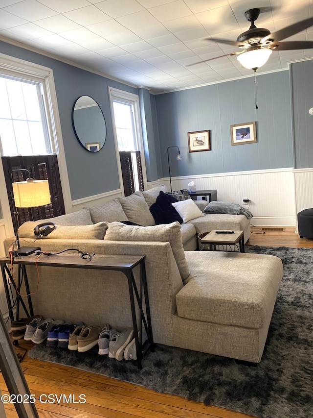 living area featuring ornamental molding, a ceiling fan, and wood finished floors