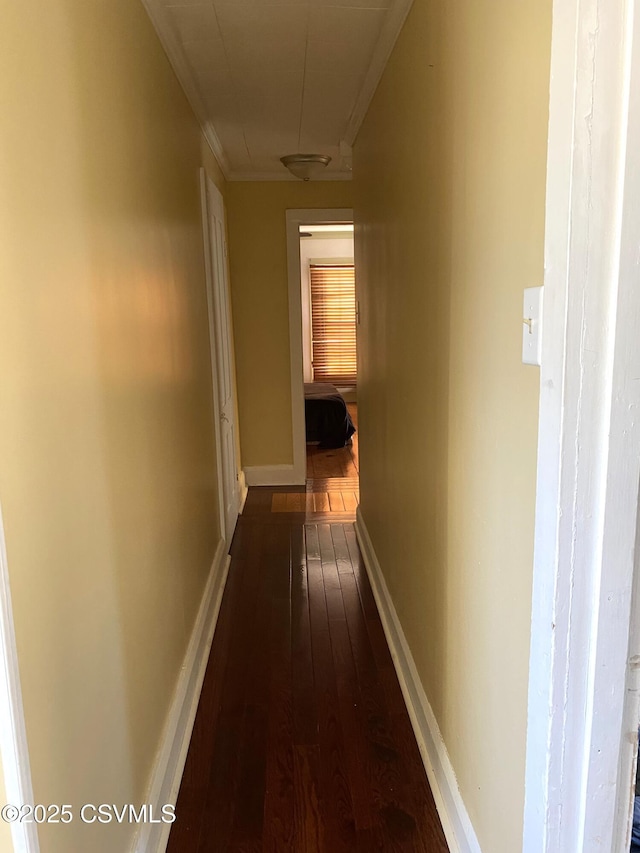 hallway featuring baseboards and dark wood-style flooring