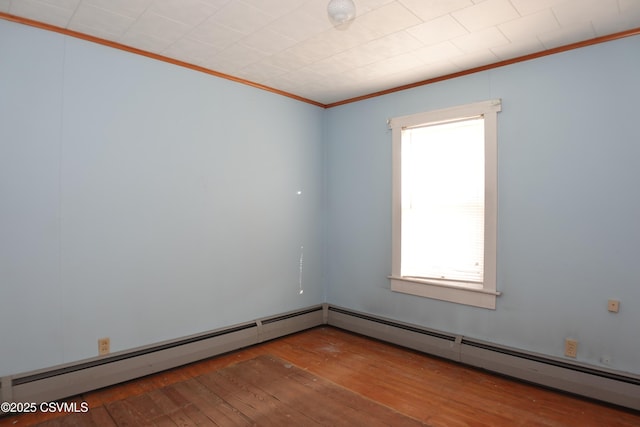 empty room featuring hardwood / wood-style flooring, ornamental molding, and a baseboard radiator