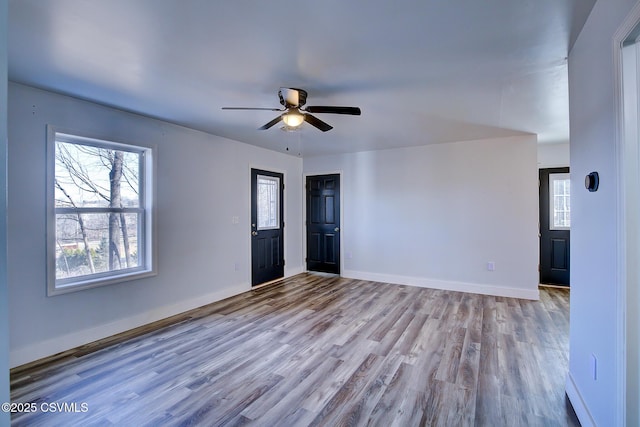 unfurnished room with ceiling fan, baseboards, and wood finished floors