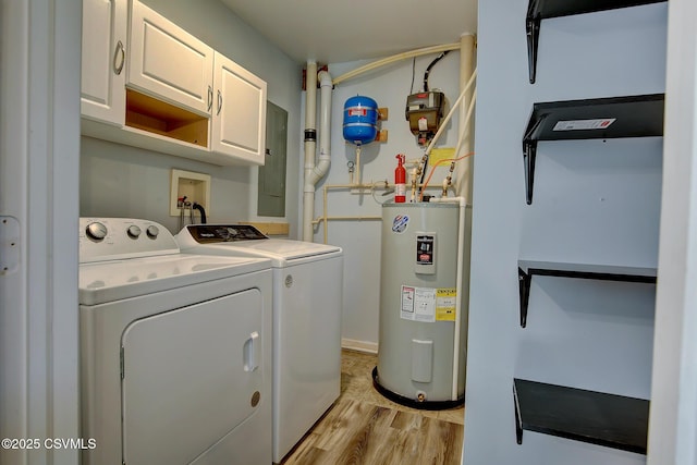 laundry area featuring electric water heater, light wood-style floors, electric panel, cabinet space, and washer and clothes dryer